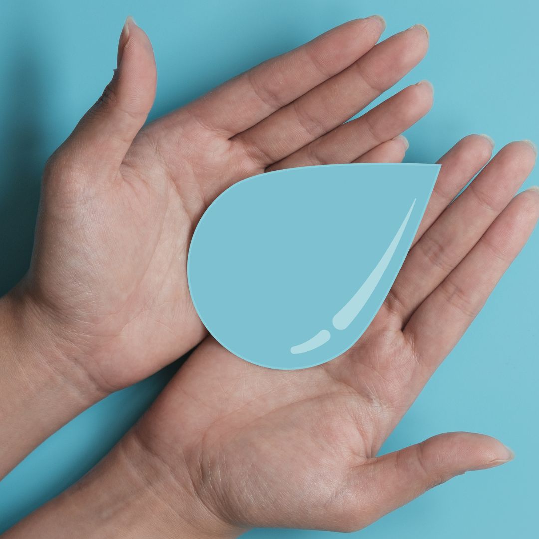 paper or cardboard water droplet in hands for conservation and sustainability and reducing water waste