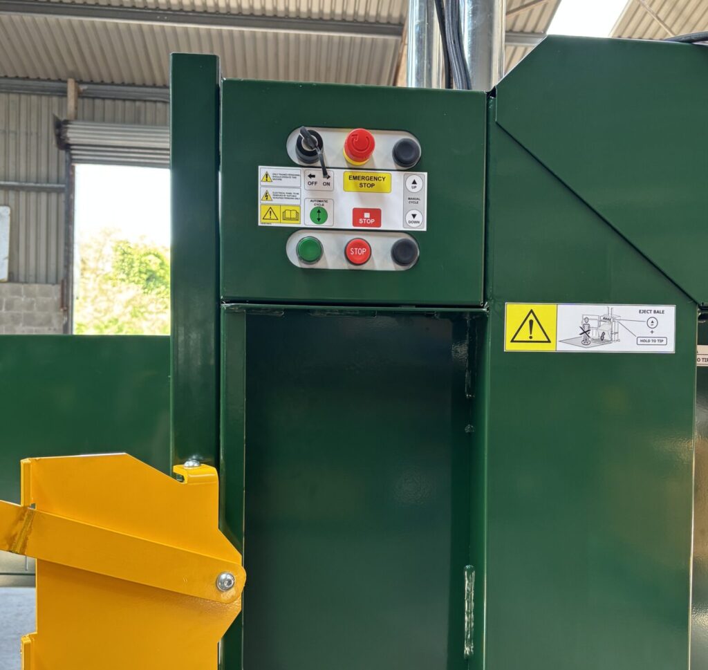 close up of control panel on baler with emergency stop button